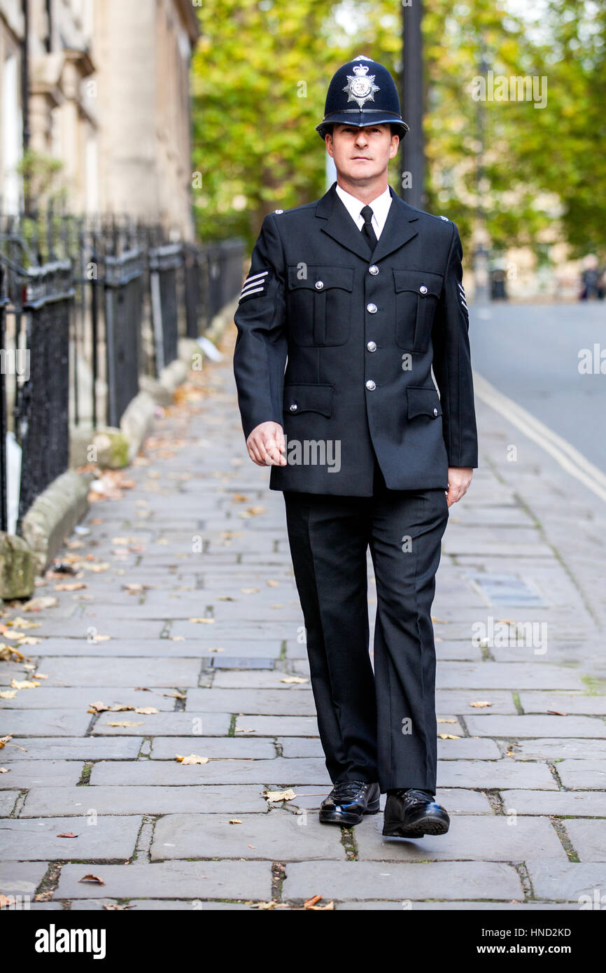 A Smartly Dressed English Policeman In Full Uniform Patrolling His