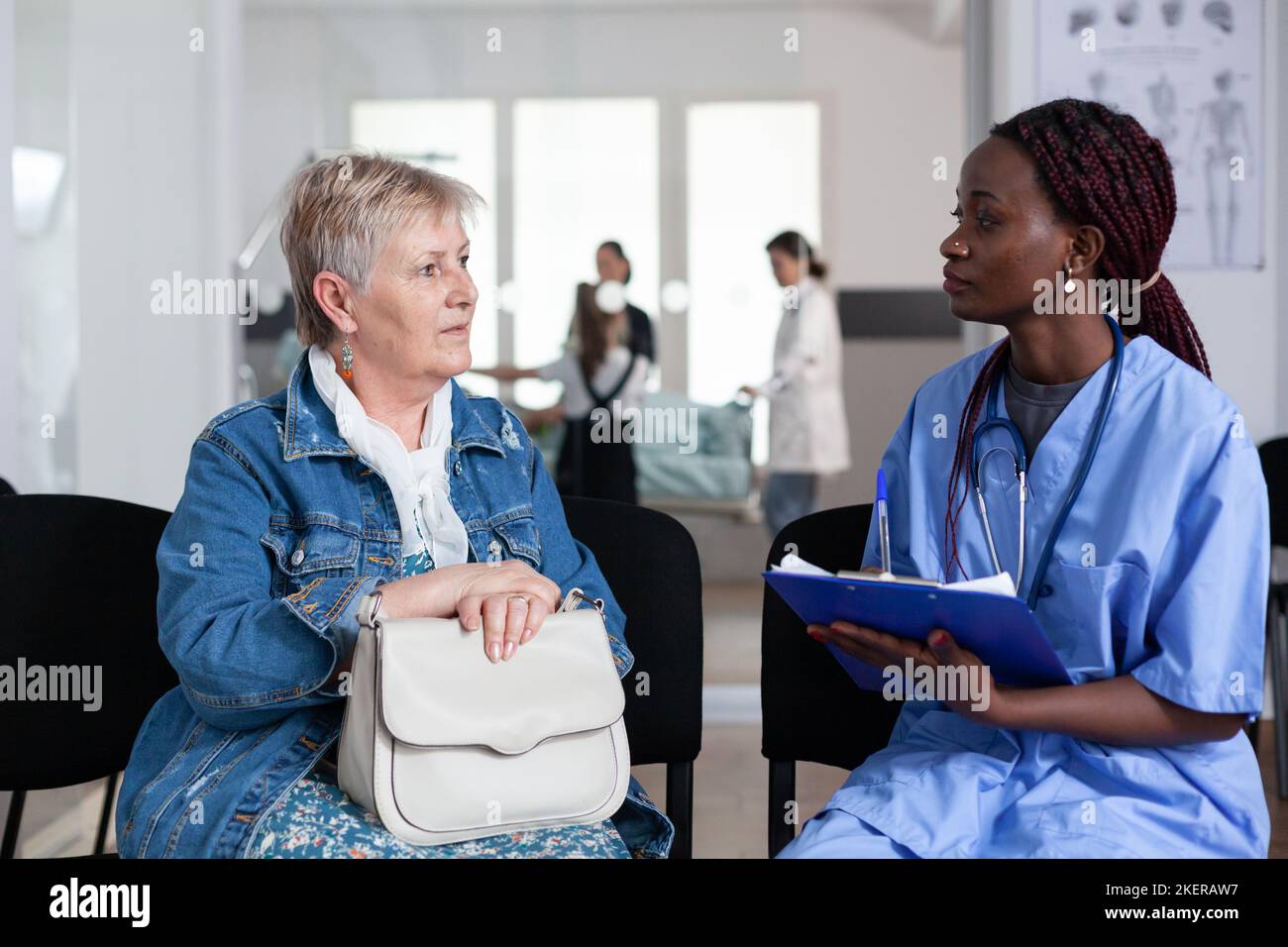 African American Nurse Filling Out Elderly Woman Admission Paperwork