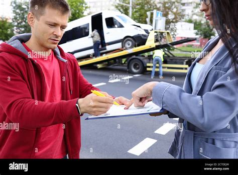 An Agent Fills Out Paperwork After Car Accident Stock Photo Alamy