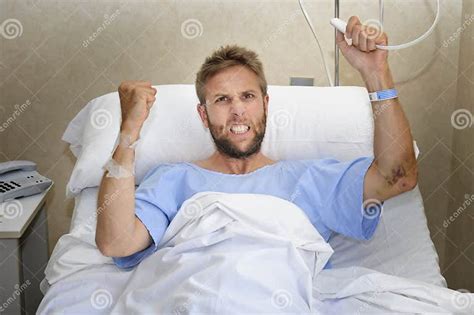 Angry Patient Man At Hospital Room Lying In Bed Pressing Nurse Call Button Feeling Nervous And