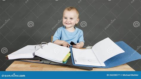 Baby With Paperwork At Wooden Desk Royalty Free Stock Photography