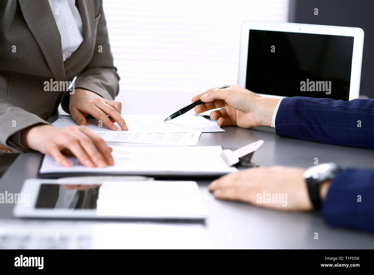 Business People And Lawyer Discussing Contract Papers Sitting At The