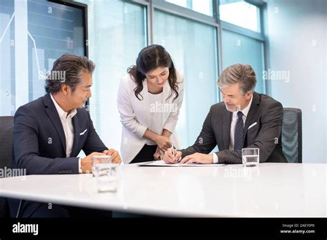 Business People Signing Contract In Conference Room Stock Photo Alamy