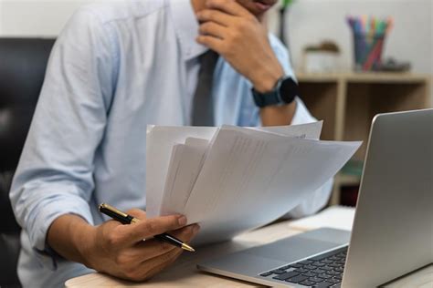 Businessman Holding Paperwork Document Graph Report Accounting And Finance Investment On Desk