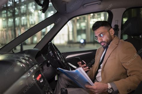 Businessman Reading Paperwork In Car At Night Stock Image F022 5359