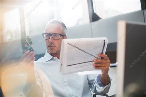 Businessman Reading Paperwork Stock Image F015 0446 Science Photo