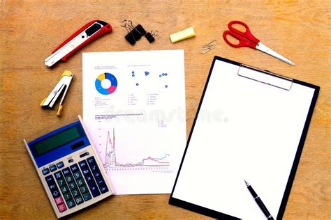 Businessman Working On A Laptop At Office Desk With Paperwork And Other