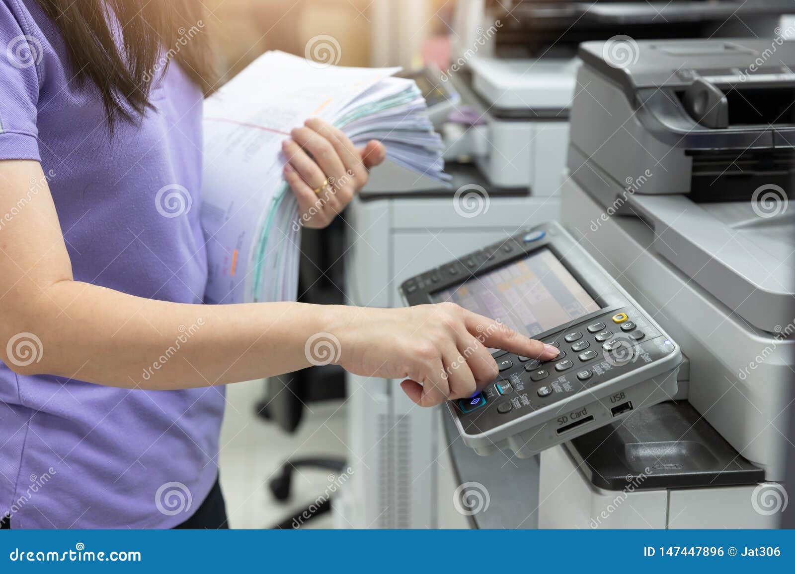 Bussinesswoman Using Copier Machine To Copy Heap Of Paperwork In Office