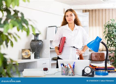 Clerical Worker With Folder In Hands Standing In Office Stock Photo