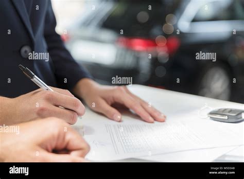 Close Up Customer Signing Financial Contract Paperwork In Car