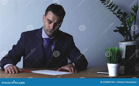 Close Up Of A Focused Young Businessman In Formal Wear Carefully