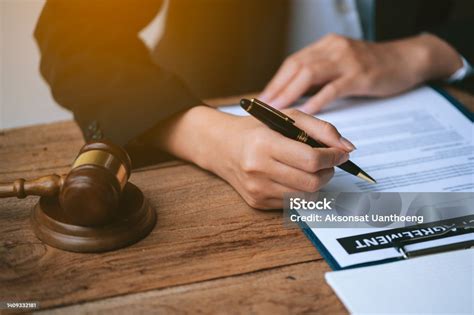 Close Up Of Lawyers Hands Is Singing On Agreement Paperworks On Table