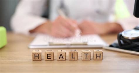 Closeup Of Doctor Hands Filling Out Medical Insurance Paperwork Stock