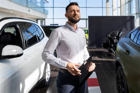 Confident Businessman Filling Out Paperwork For Buying A New Car At A