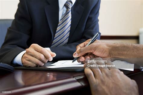 Customer Signing Paperwork With Bank Manager High Res Stock Photo