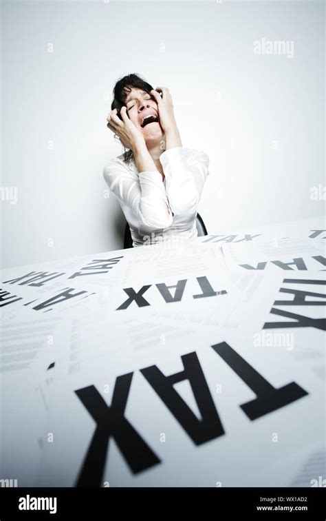 Desperate Woman At Her Taxes Paperwork Covered Desk To Crying Bitter Tears With Her Hands On