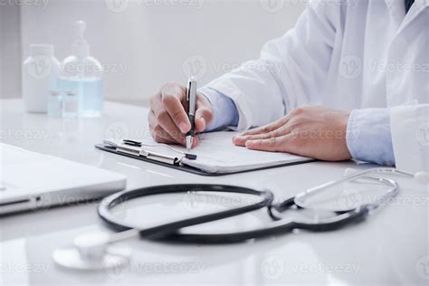 Doctor Doing Paperwork And Using Laptop In Clinic Description Into A Server Computer In