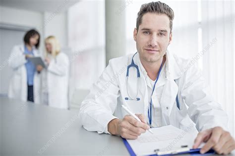 Doctor Doing Paperwork Stock Image F022 7140 Science Photo Library