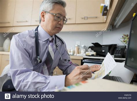 Doctor Reviewing Paperwork Doctors Office 60 64 Stock Photo Alamy