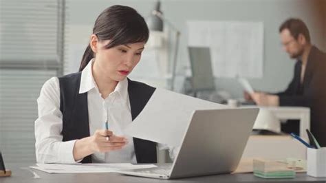 Female Asian Engineer Doing Paperwork In Office Industrial Stock