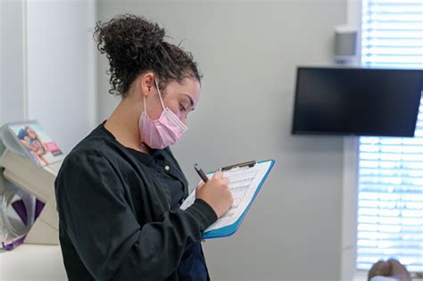 Female Dentist Does Paperwork On Clipbaord Stock Photo Download Image