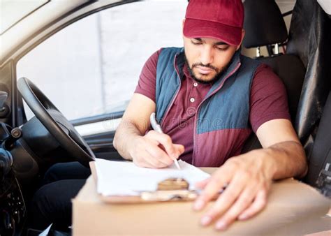 Filling Out The Paperwork A Handsome Young Male Courier Out Making