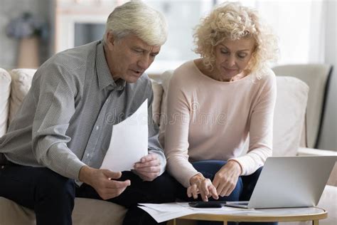 Focused Retired Married Couple Checking Paper Stock Photo 2197756359