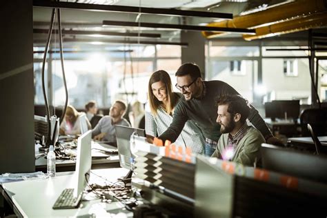 Group Of Computer Programmers Working On Reports At Corporate Office Stock Photo Download