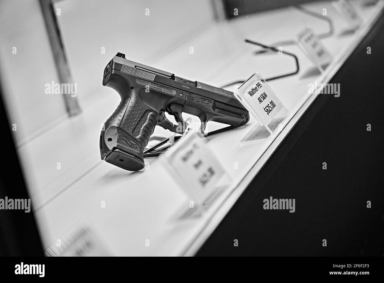 Handguns With Labels And Price Tags On Sale On Shelves At Gun Store