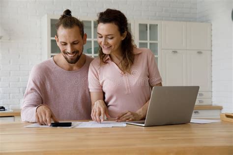 Happy Couple Of Tenants Doing Domestic Paperwork In Kitchen Stock Image