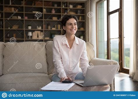 Happy Thoughtful Young Homeowner Woman Doing Domestic Paperwork Stock