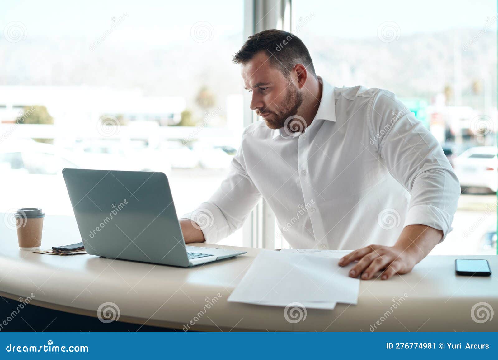 Having The Correct Paperwork Matters A Young Car Salesman Filling Out Paperwork In His Office