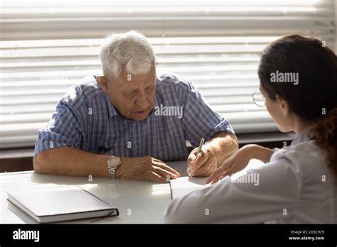 Mature Male Patient Sign Paperwork In Hospital Stock Photo Alamy