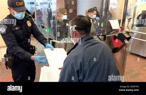 Mexican Immigrant Passing Documents To Cbp Official At Processing