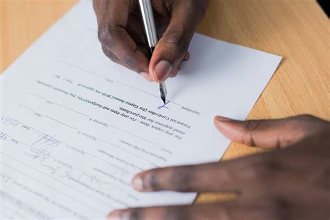 Person Signing Paper Free Stock Photo