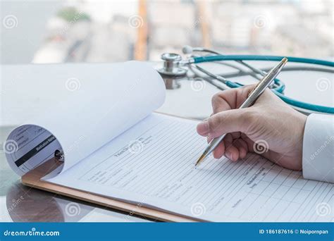 Physician Doctor Writing On Medical Health Care Record Patients