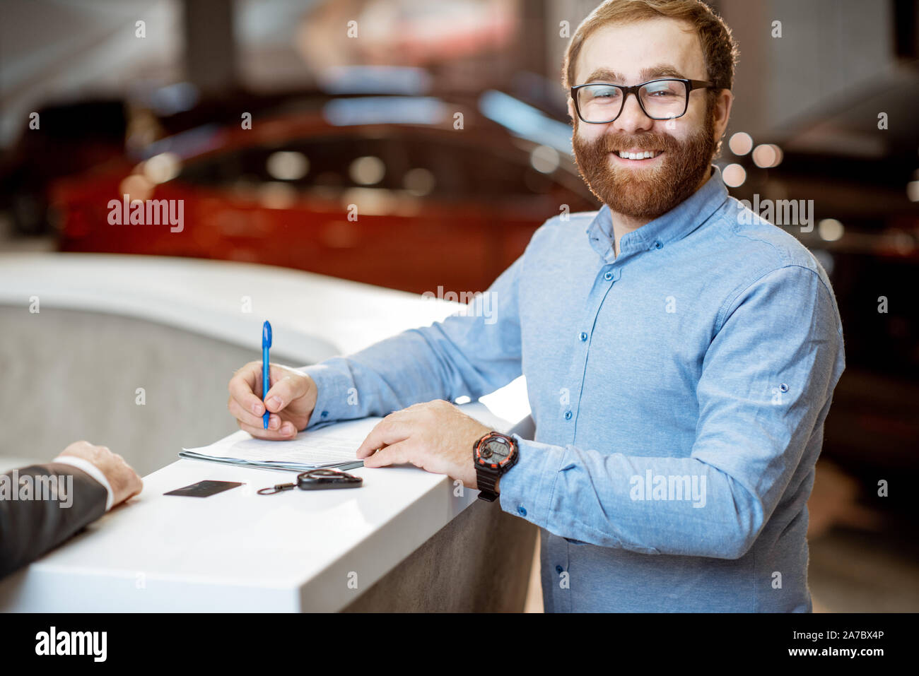 Portrait Of A Young Man As A Happy Buyer Signing Some Documents Buying