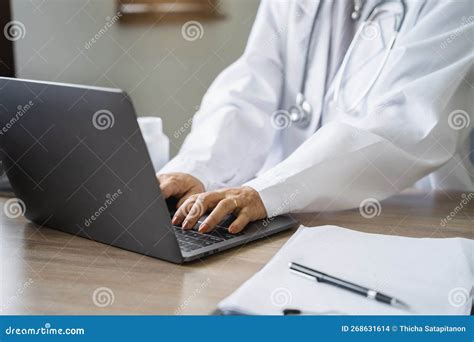 Premium Photo Doctor Working With Laptop Computer And Writing On Paperwork In The Room