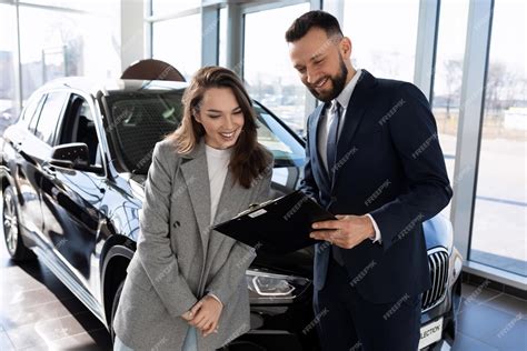 Premium Photo Sales Assistant In A Car Dealership Introduces A Woman