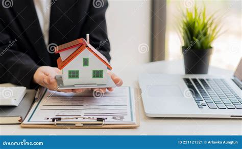 Real Estate Agents Work In The Office With Paperwork And Offer A House