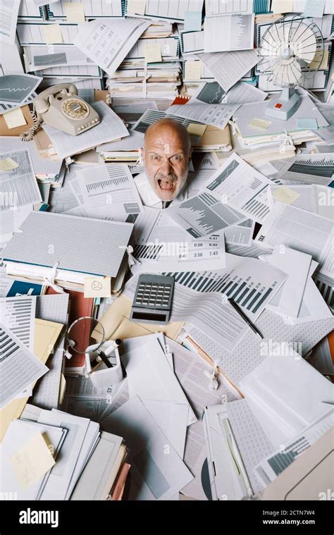 Screaming Businessman Drowning Under A Lot Of Paperwork In The Office He Is Overwhelmed By Work