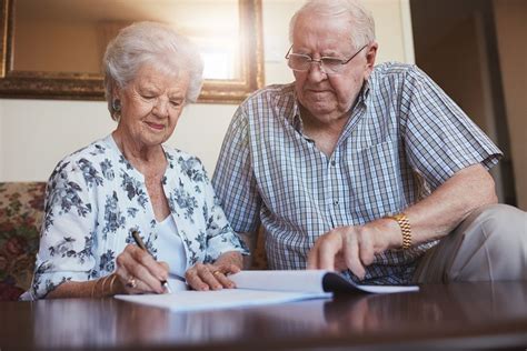 Senior Couple Doing Retirement Paperwork Heritage Reverse Mortgage