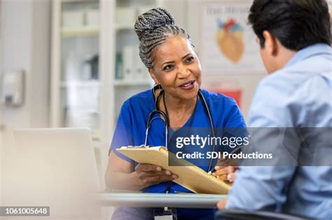 Senior Nurse Explains Paperwork To New Patient High Res Stock Photo