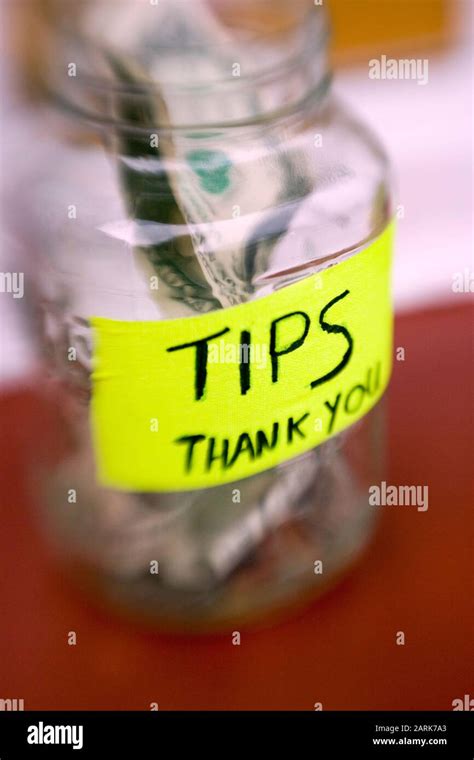 Still Life Of A Tip Jar With Bills And Coins At A Local Restaurant