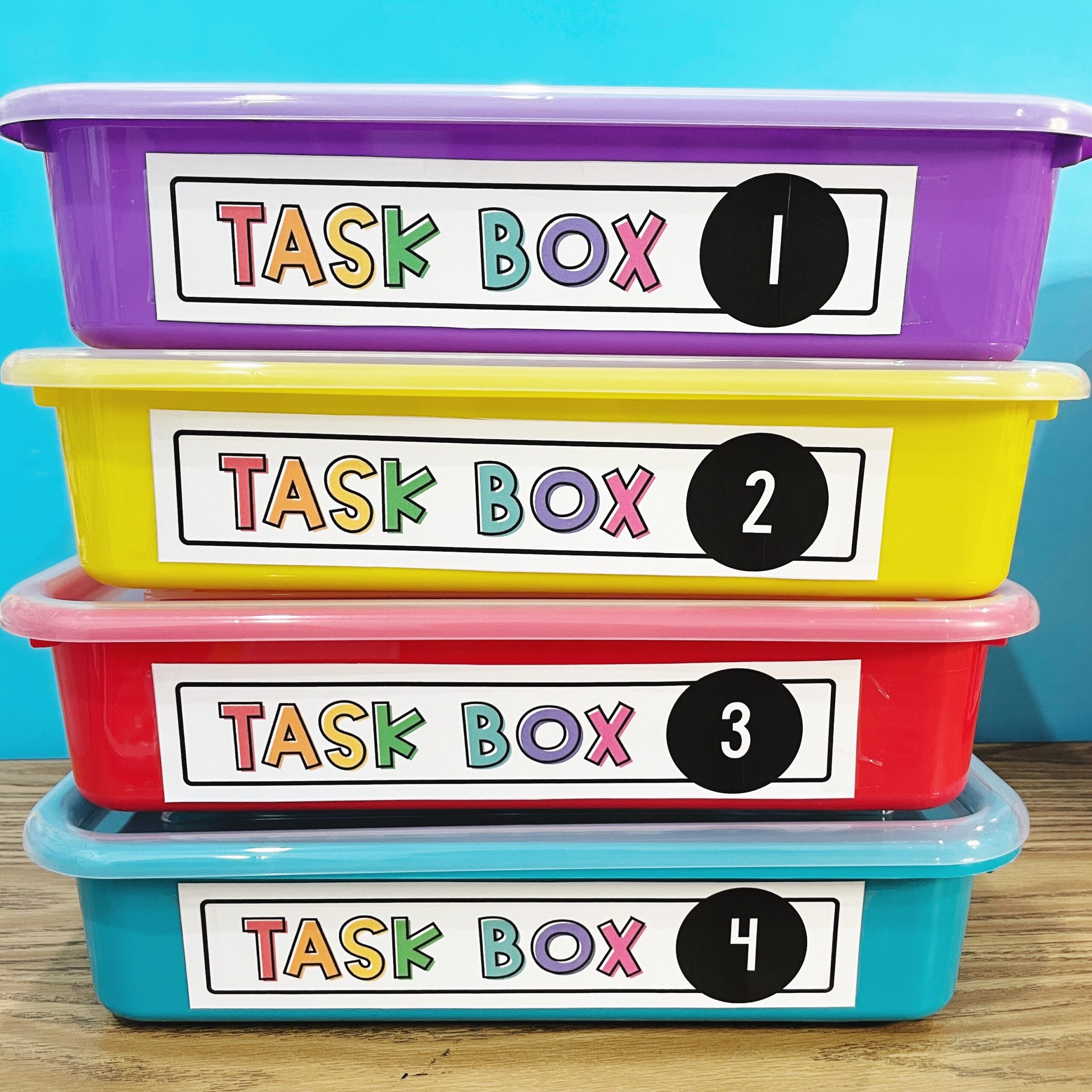 The Bookshelf Has Three Blue Bins And Two White Boxes With Different Types Of Books On Them