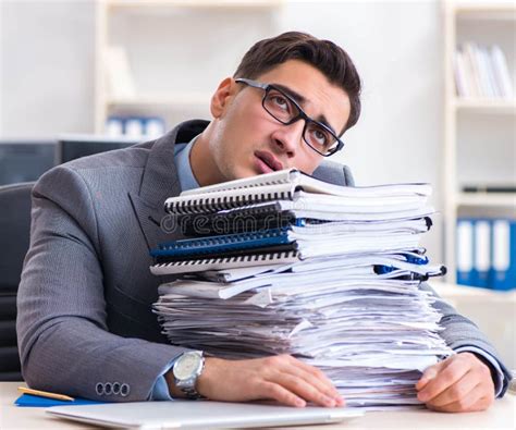 The Overloaded With Work Employee Under Paperwork Burden Stock Photo