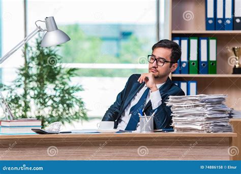 The Young Businessman In Stress With Lots Of Paperwork Stock Photo