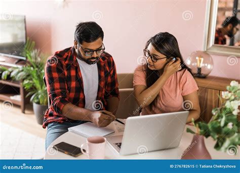 Young Millennial Indian Husband And Wife Doing Domestic Paperwork