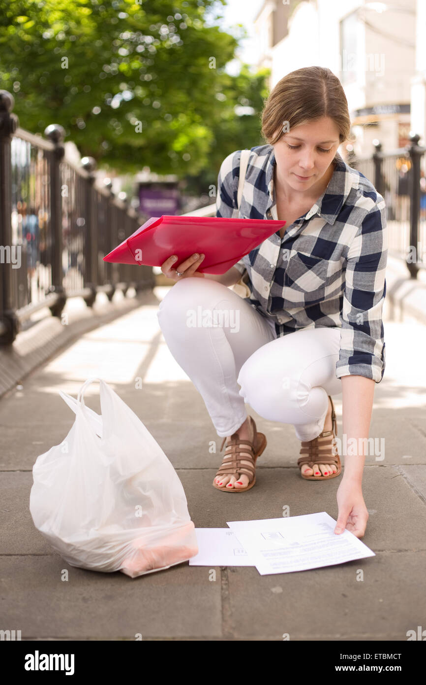 Young Woman Picking Up Dropped Paperwork Stock Photo Alamy